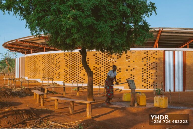Design-and-Build, or Architect and Contractor Separately? A Straight Comparison 2 Woman Fetching Water At Brick Pavilion Borehole Pump. YHDR Builders Uganda Ltd carries out borehole drilling and construction.